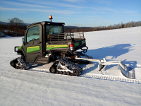 Užitková terénní čtyřkolka John Deere XUV 865M umí odhrnovat sníh radlicí. A dokáže nejen to, po přezutí do pásů připraví stopu pro běžkaře.